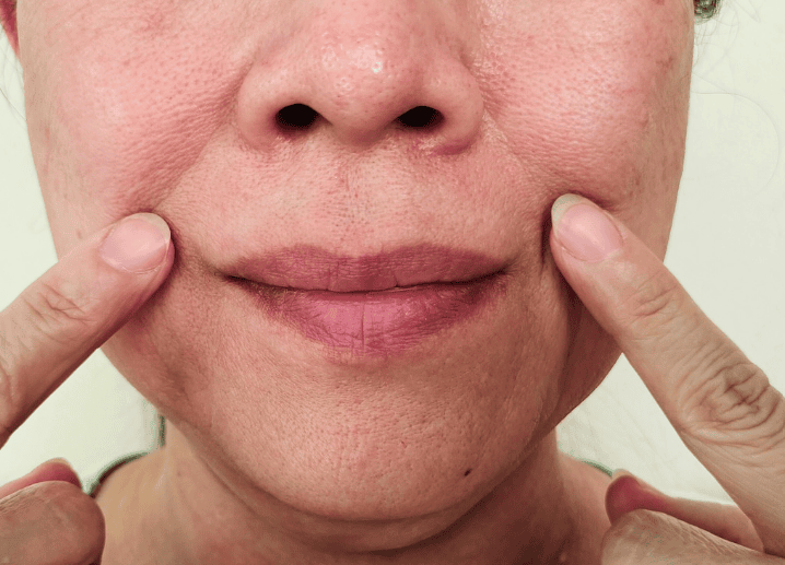 A woman with her hands on her face, expressing surprise or contemplation.